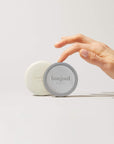 Woman's hand holding Bonjout Beauty's Le Balm product and refill tin