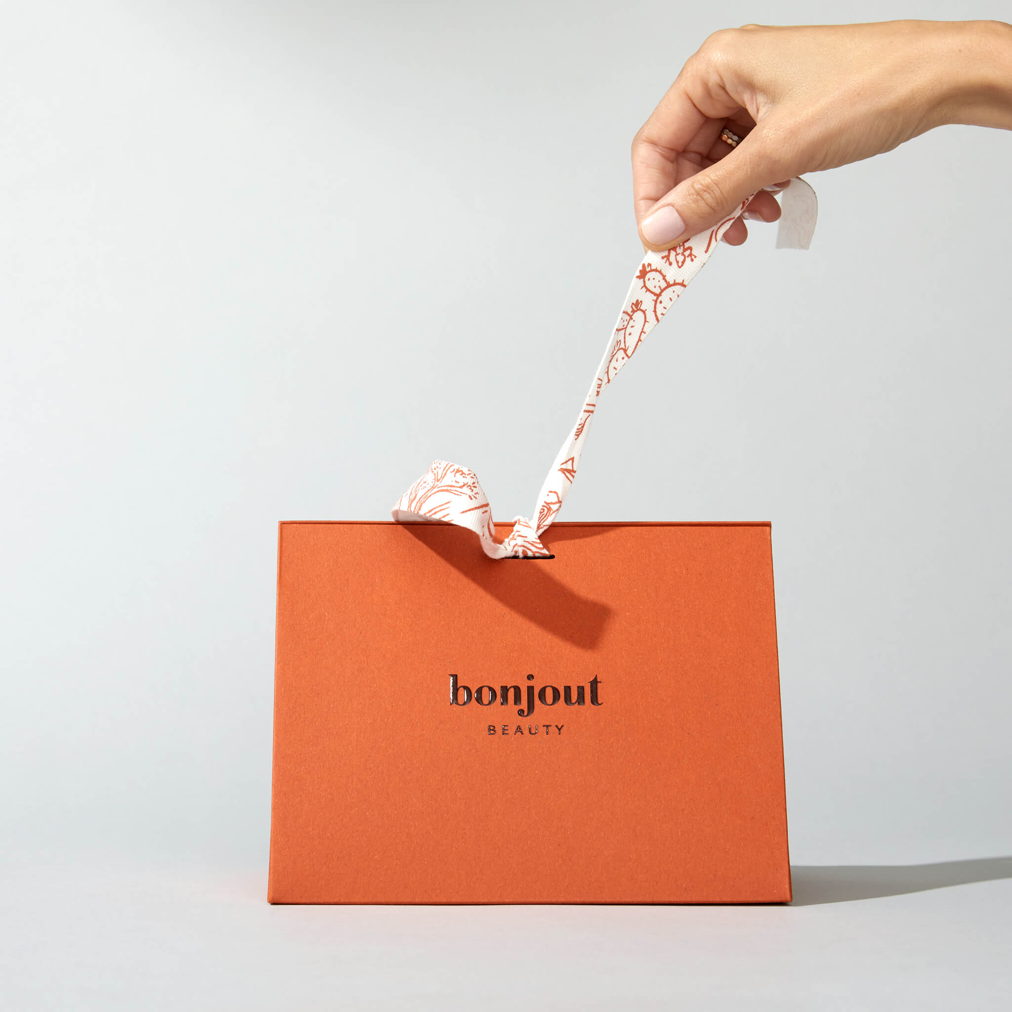 Woman unwrapping Bonjout Beauty's Le Balm Gift Box
